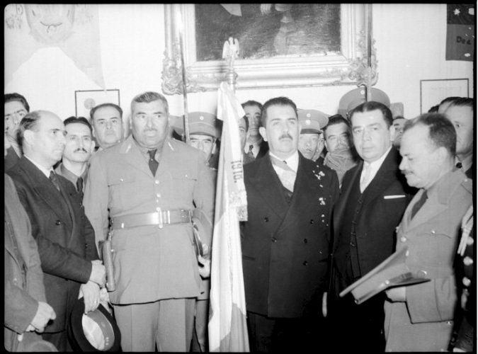 con mujica.png Francisco Múgica, extrema derecha, asiste a una ceremonia presidida por el General Lázaro Cárdenas. Reproducción autorizada por el INAH.